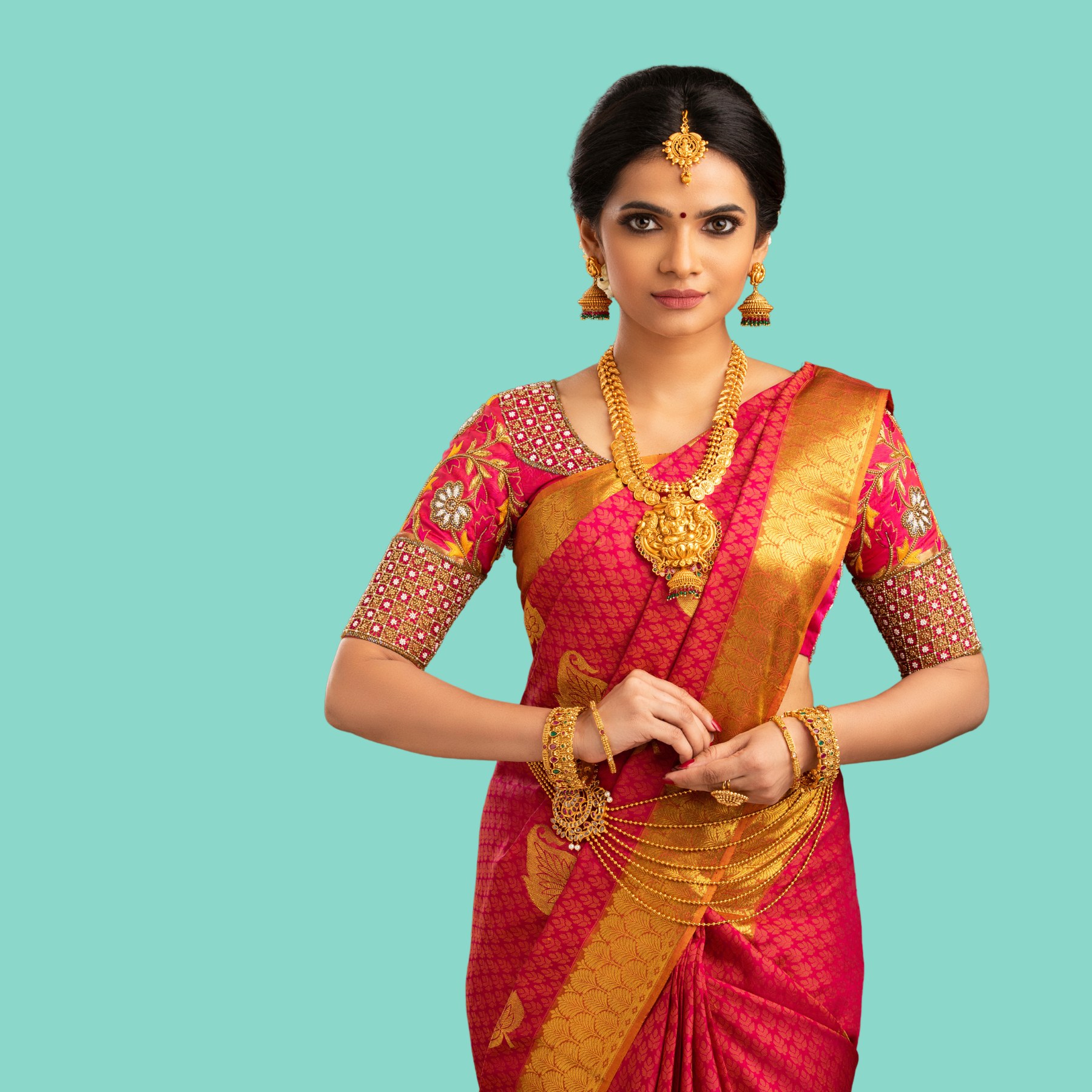 A practitioner in a red and gold sari with ceremonial presence against a marine background