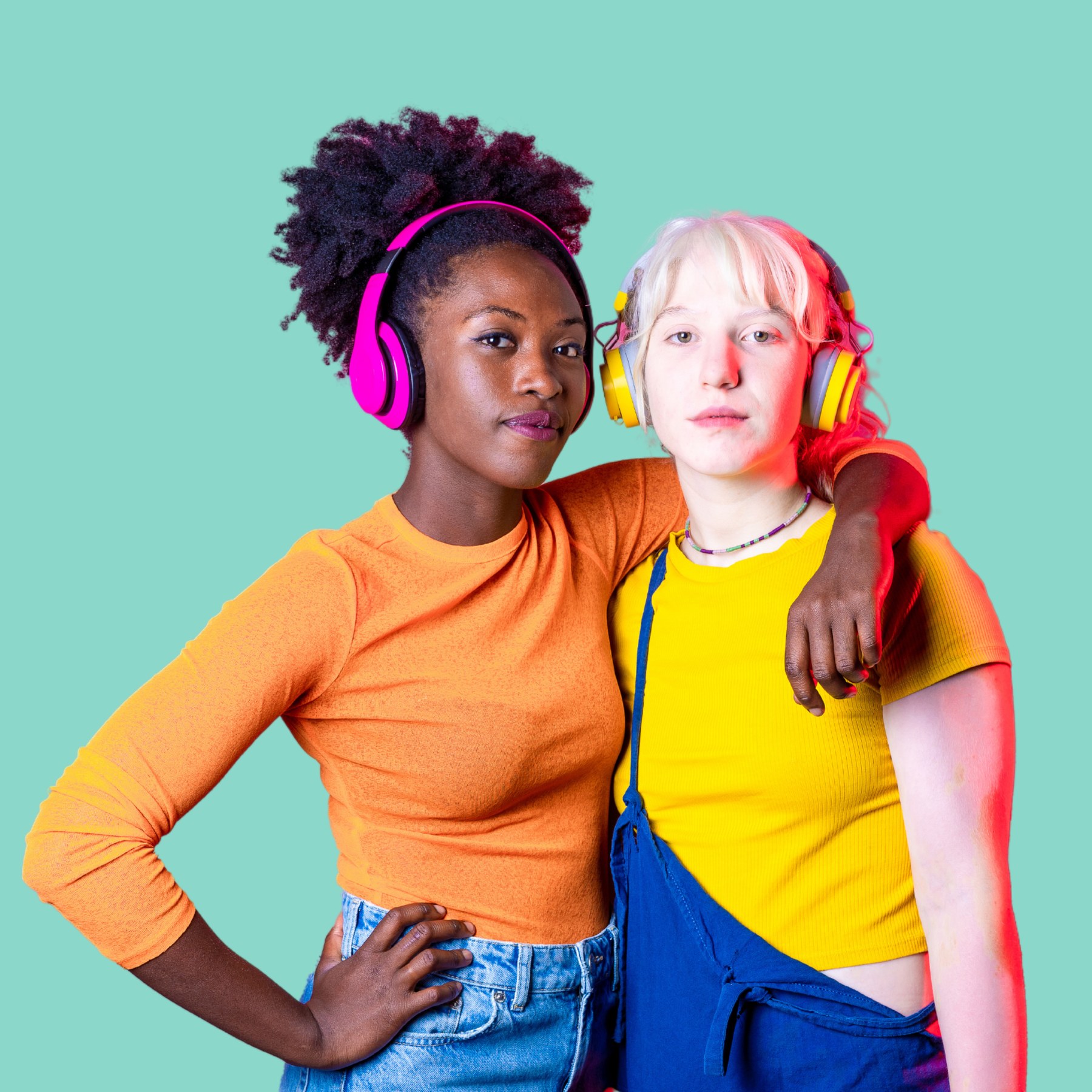 Two practitioners side by side with headphones, conveying peer connection and community energy against a marine background