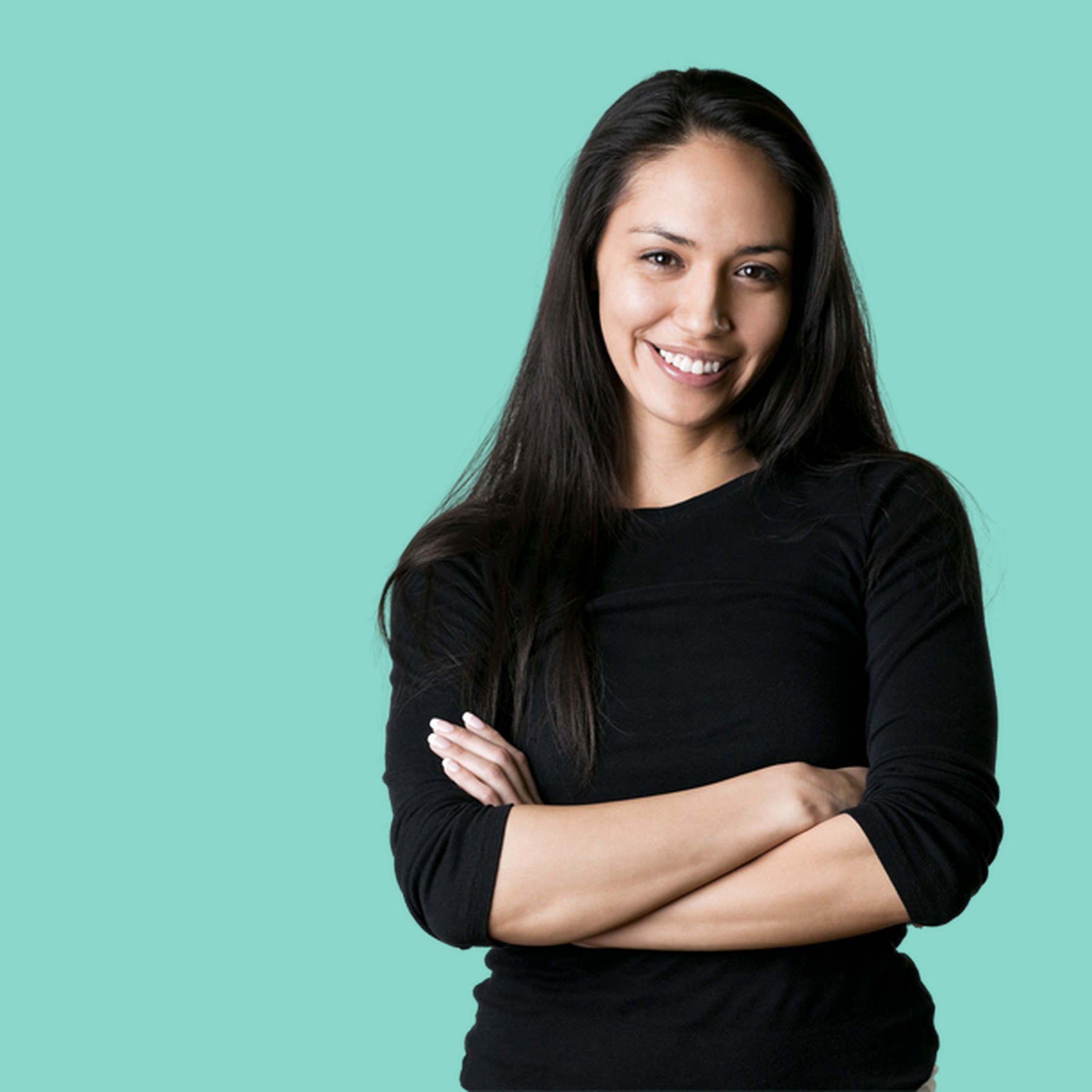A confident leader in a green dress with arms crossed, conveying strength and approachability against a marine background