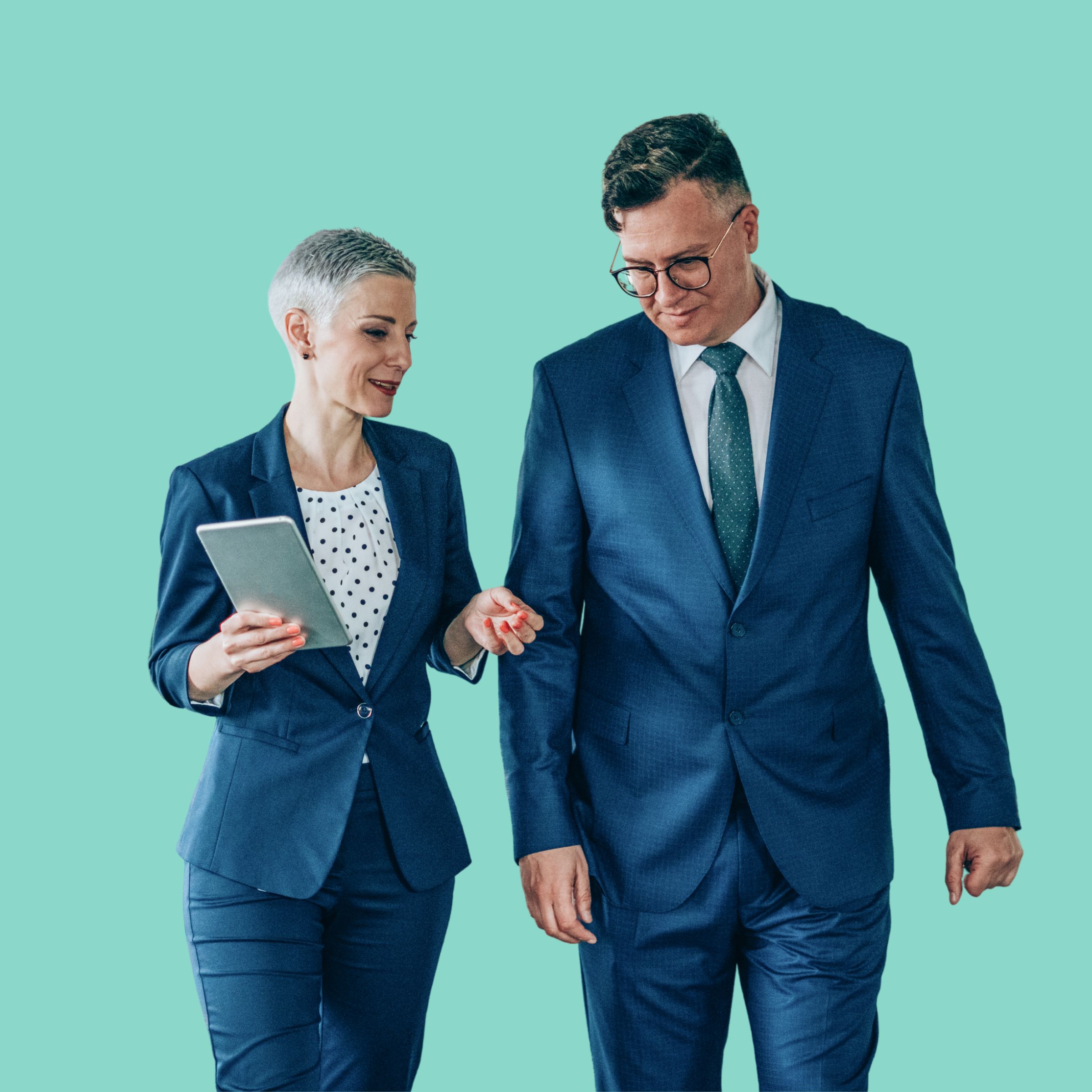 Two professionals in blue suits walking together while reviewing a tablet, against a turquoise background